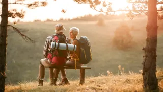 elderly couple sitting on bench outdoors