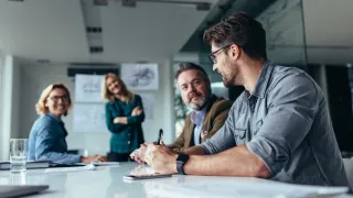 Business meeting around a white table.