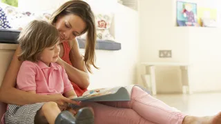 Mother and child reading a book together.