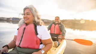 Older couple in canoe while sun sets