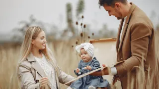 mom dad and baby in field