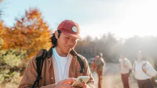 young man on a hike, using his phone