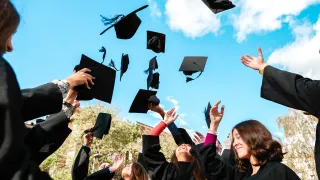 Graduates throwing caps on graduation day