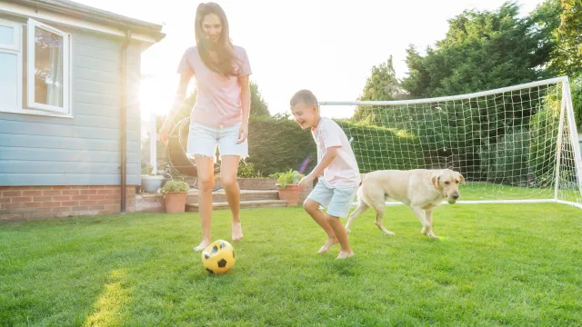 Mother and child on lawn playing soccer
