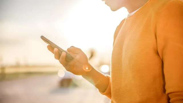 Person holding a phone outdoors