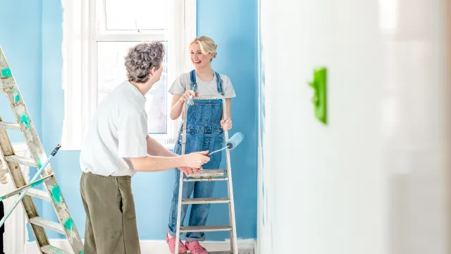 Woman and man in house painting walls