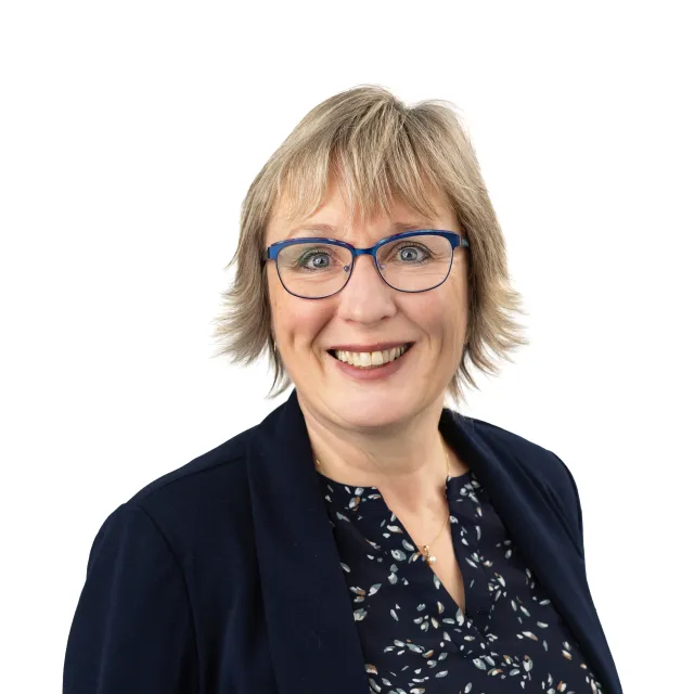 Smiling woman wearing glasses and a blue blazer.